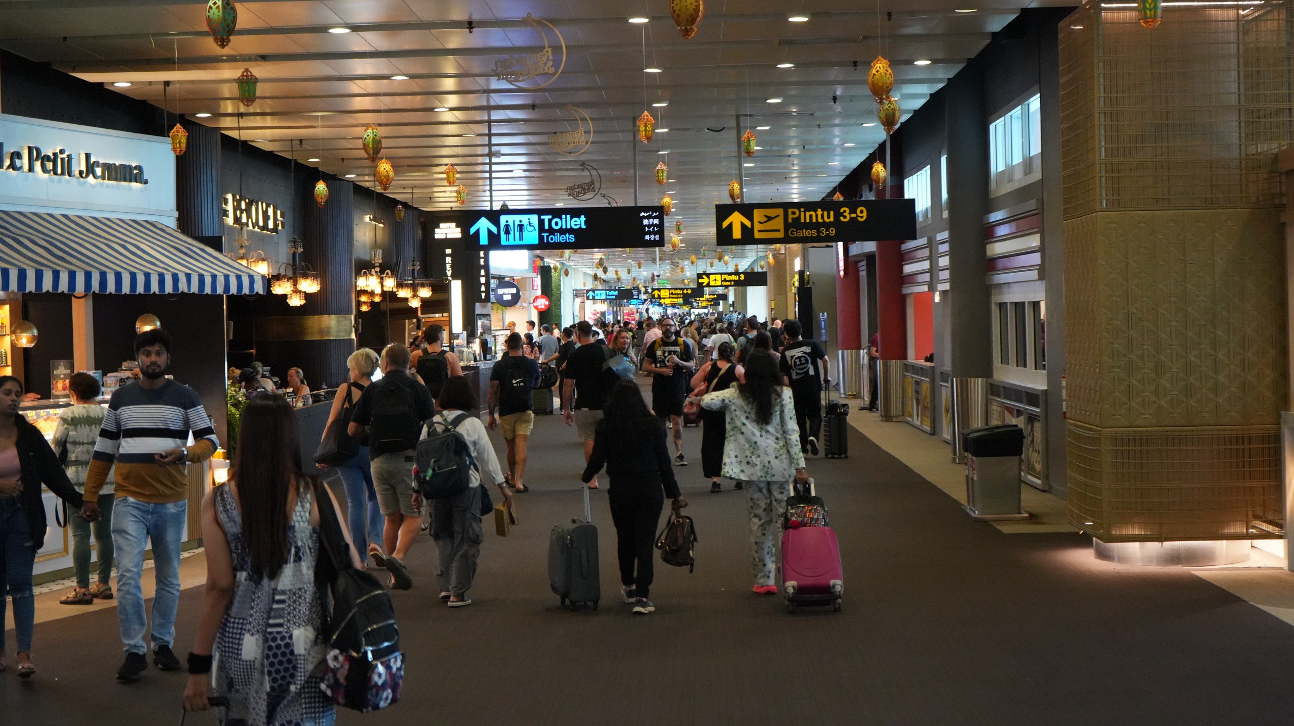 Suasana terminal Bandara Internasional I Gusti Ngurah Rai dengan aktivitas penumpang meningkat pada awal 2025.