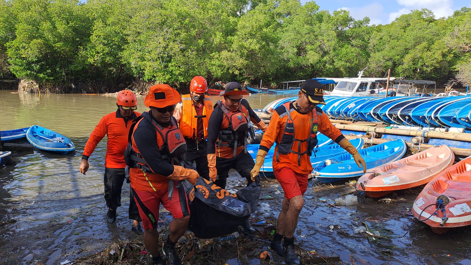 Tim SAR mengevakuasi korban banjir di muara Waduk Tukad Badung, Bali.