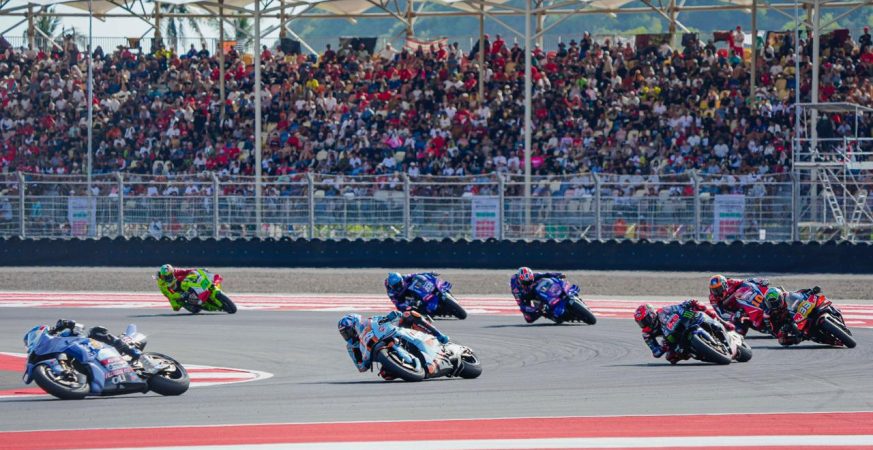Aksi balapan Pertamina Grand Prix of Indonesia 2025 di Sirkuit Mandalika dengan penonton memenuhi tribun.