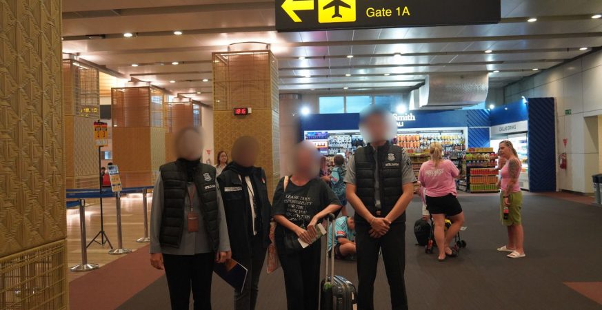 Ngurah Rai Immigration officers escort French woman for deportation at Bali airport.